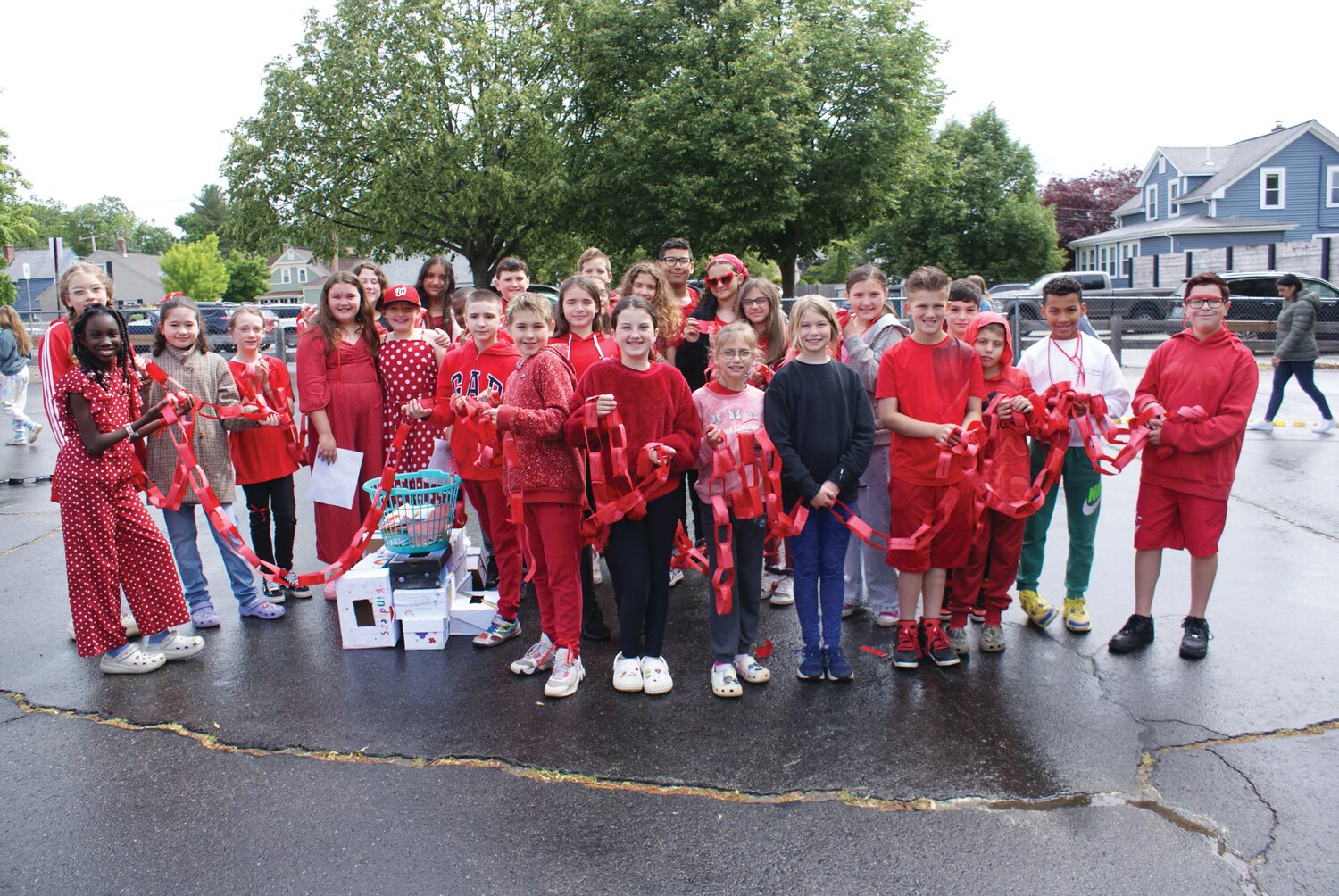 JOB WELL DONE: The Fifth grade class of Oak Lawn elementary dresses in red to match their section of the “kindness chain” they organized and built in the hopes of bringing the whole school together in the name of kindness. (Photo by Steve Popiel)